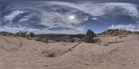 a 360 view of the desert looking back towards the sky with a full moon in it