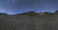 a long time lapse image shows the rocky mountains below a night sky full of stars