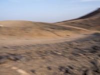 a truck on a dirt road in the desert with rocks and stones on the ground