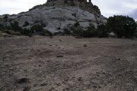 there is a rock on the side of this hill in the desert and there is dirt in the middle