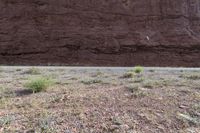 a person riding a motorcycle along a narrow road through rocks and sand cliffs a grassy area on both sides