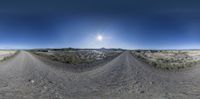 a panorama photo of a desert road at the bottom of the mountain, on an empty sunny day