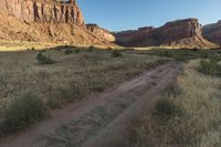 the dirt trail is on the edge of the mountain range in the desert area of the area