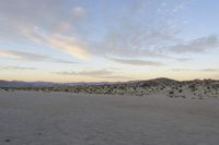 a car parked on the side of the road by the mountains in the desert, near a man