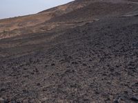 a truck on a dirt road in the desert with rocks and stones on the ground