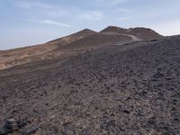 a truck on a dirt road in the desert with rocks and stones on the ground