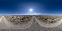 an image of a dirt road taken in a 360 lens on a sunny day in the desert