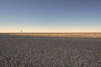 a lone airplane flying above the plain of an empty, dry area in the middle of a desert