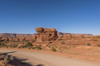 a dirt road with rocks on it near a rocky mountain range that looks like desert