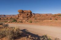 a dirt road with rocks on it near a rocky mountain range that looks like desert