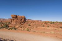 a dirt road with rocks on it near a rocky mountain range that looks like desert