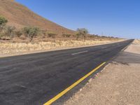 a road with two lanes and no traffic on it in the desert setting of the day