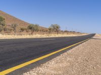 a road with two lanes and no traffic on it in the desert setting of the day