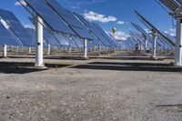 a row of solar panels with one bright yellow ball hanging above it in the sky