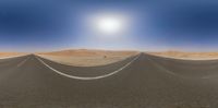 an empty street in the desert between two flags and hills of sand and blue skies