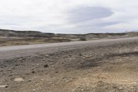 a sign warning of an approaching vehicle on the highway through rocky terrain in a dry, barren area