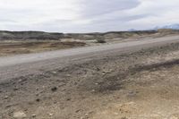 a sign warning of an approaching vehicle on the highway through rocky terrain in a dry, barren area