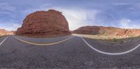 the panoramic shot is looking straight ahead at a mountain in the distance and the road is empty