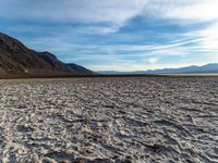 the mountains are next to the dry lake in the desert at sunset - looking down into the water