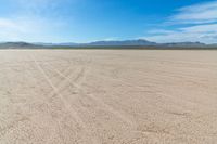 a field with tracks in it, in the middle of nowhere, in the desert