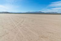 a field with tracks in it, in the middle of nowhere, in the desert