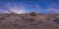 an old house sits in the middle of the desert during the sun set as seen from below