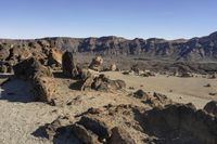 the view of the desert with rocks in the foreground and mountains in the distance