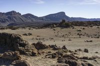 the view of the desert with rocks in the foreground and mountains in the distance