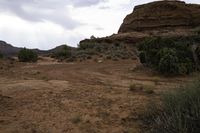 a barren, rocky area that is mostly open to the elements, including mountains and a red rock