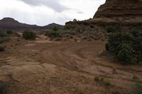 a barren, rocky area that is mostly open to the elements, including mountains and a red rock