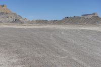 a red truck is driving through the rocky landscape of the desert of an arid area