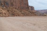 a dirt road with some rocks on both sides and dirt running on each side with steep cliffs at the bottom and bottom