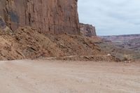 a dirt road with some rocks on both sides and dirt running on each side with steep cliffs at the bottom and bottom