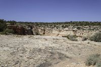 there is a big rocky area with mountains and desert vegetation on it and people on the edge of the valley