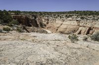 there is a big rocky area with mountains and desert vegetation on it and people on the edge of the valley