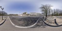 the view from a fisheye lens of buildings in a deserted city street near a parking lot