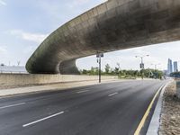 a deserted city street is shown below a bridge underpassed overpassed highway