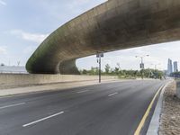 a deserted city street is shown below a bridge underpassed overpassed highway