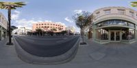 a fisheye lens of a deserted city street and palm trees as seen through the streets