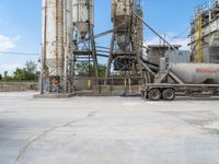 large cement plant in a deserted industrial space and equipment to make it work on the road