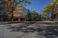 a deserted intersection near the buildings of a large city park in autumn, with a blue sky overhead