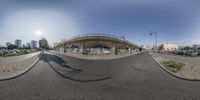 a panorama point - at - view of a deserted intersection with a bridge and many cars on the street