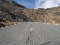 a deserted mountain road that has been paved with rocks and gravels, leading into the distance there are large rocks