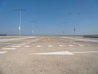 a deserted parking lot with a passenger jet coming from a runway terminal with stairs to it