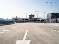 a deserted parking lot with a passenger jet coming from a runway terminal with stairs to it