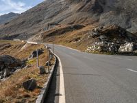 a deserted road with signs on a mountain side near the side of a hill in switzerland