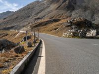 a deserted road with signs on a mountain side near the side of a hill in switzerland