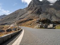 a deserted road with signs on a mountain side near the side of a hill in switzerland