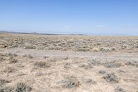 a deserted road runs through the desert in the middle of nowhere, with mountains in the distance