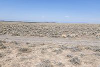 a deserted road runs through the desert in the middle of nowhere, with mountains in the distance